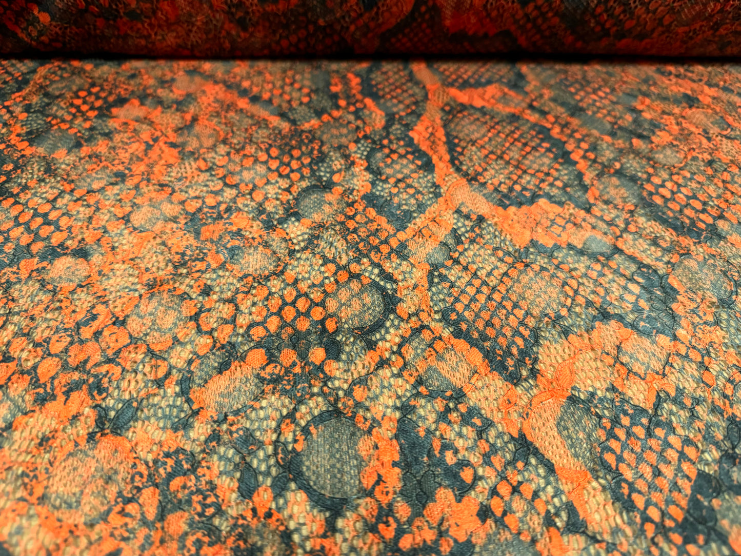 Stretch lace dress fabric with scalloped selvedge, per metre - distressed snakeskin print - burnt orange