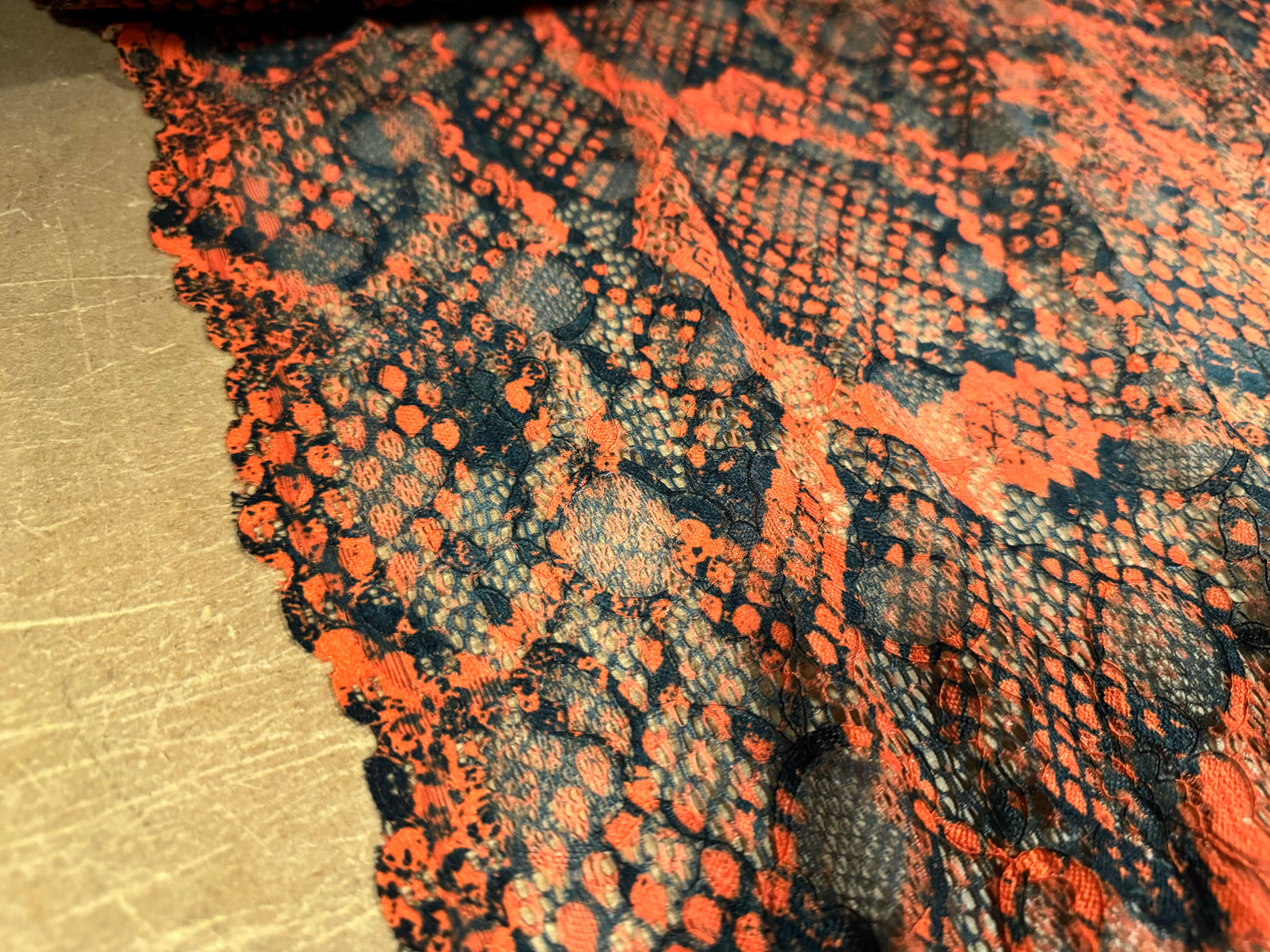 Stretch lace dress fabric with scalloped selvedge, per metre - distressed snakeskin print - burnt orange
