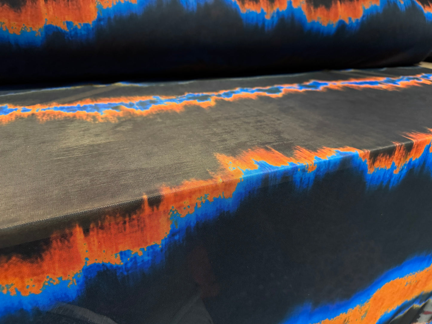 Power mesh net stretch spandex fabric, per metre - ombré volcano print - black orange & blue
