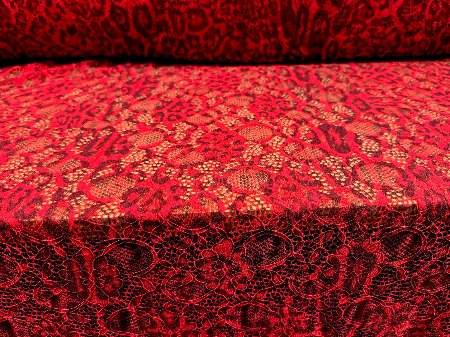 Stretch lace dress fabric with scalloped selvedge, per metre - distressed animal print - red & maroon