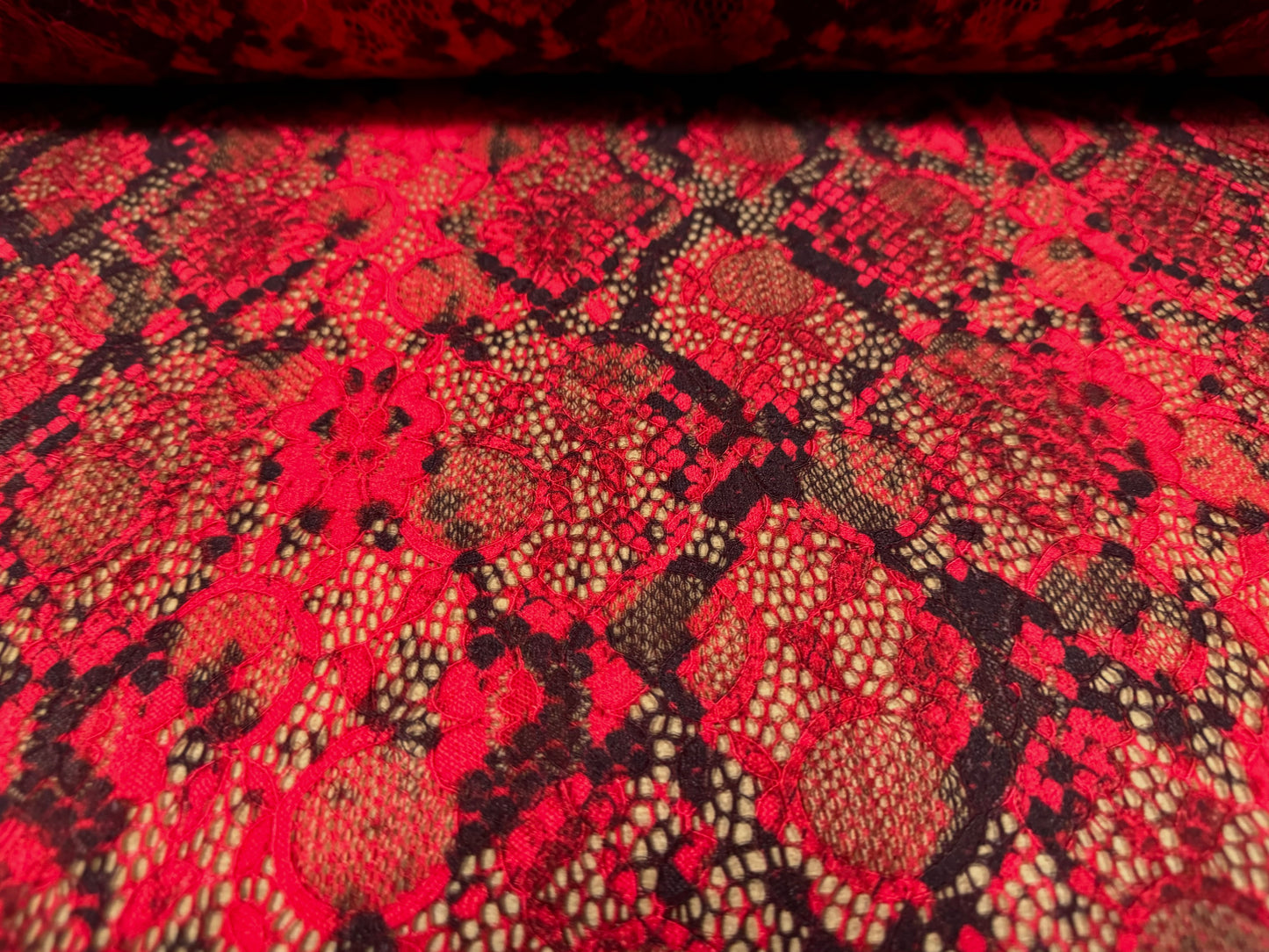 Stretch lace dress fabric with scalloped selvedge, per metre - snakeskin animal print - red & black