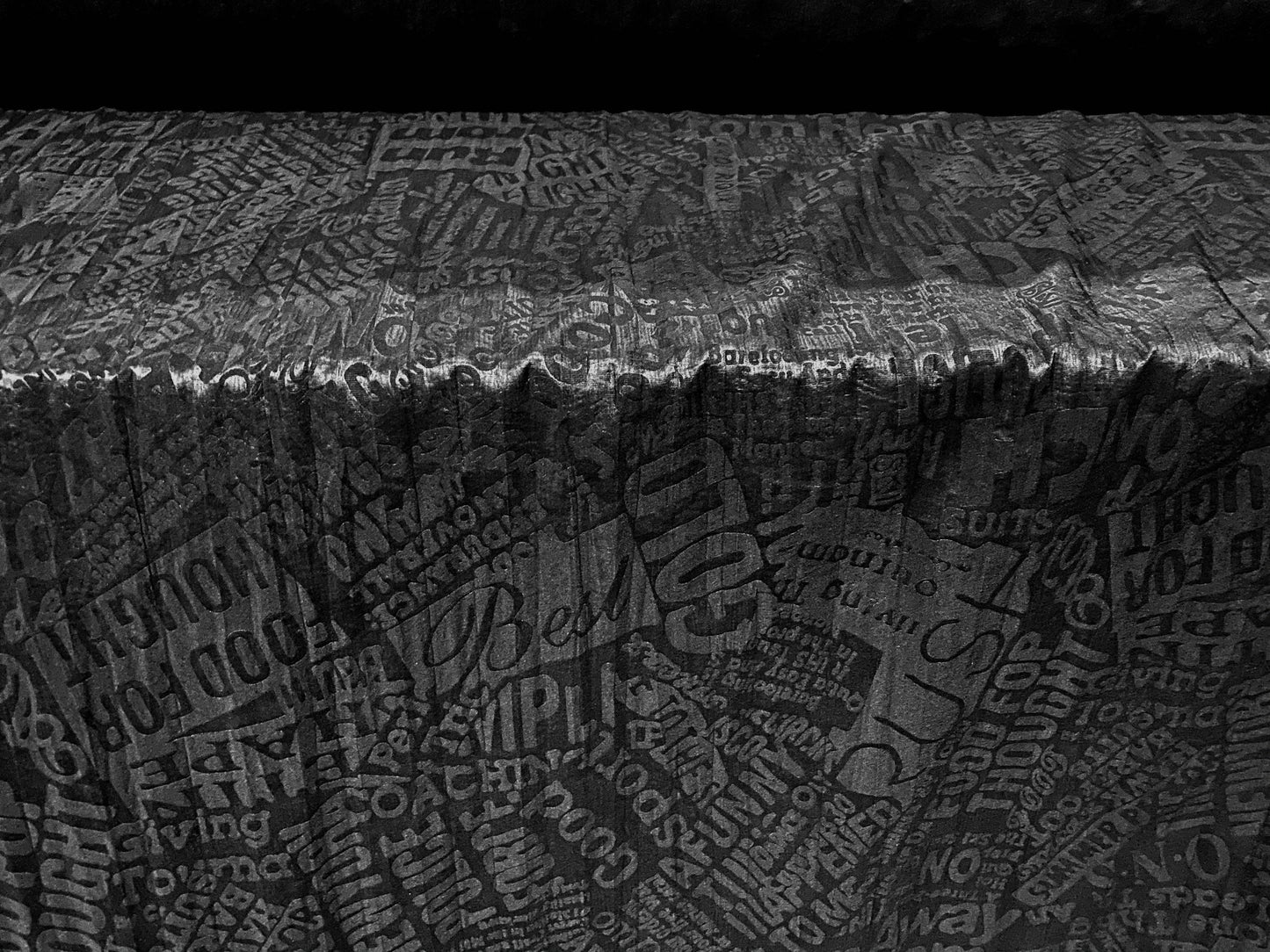 Crinkle woven dress fabric per metre, embossed fashion headlines print - black