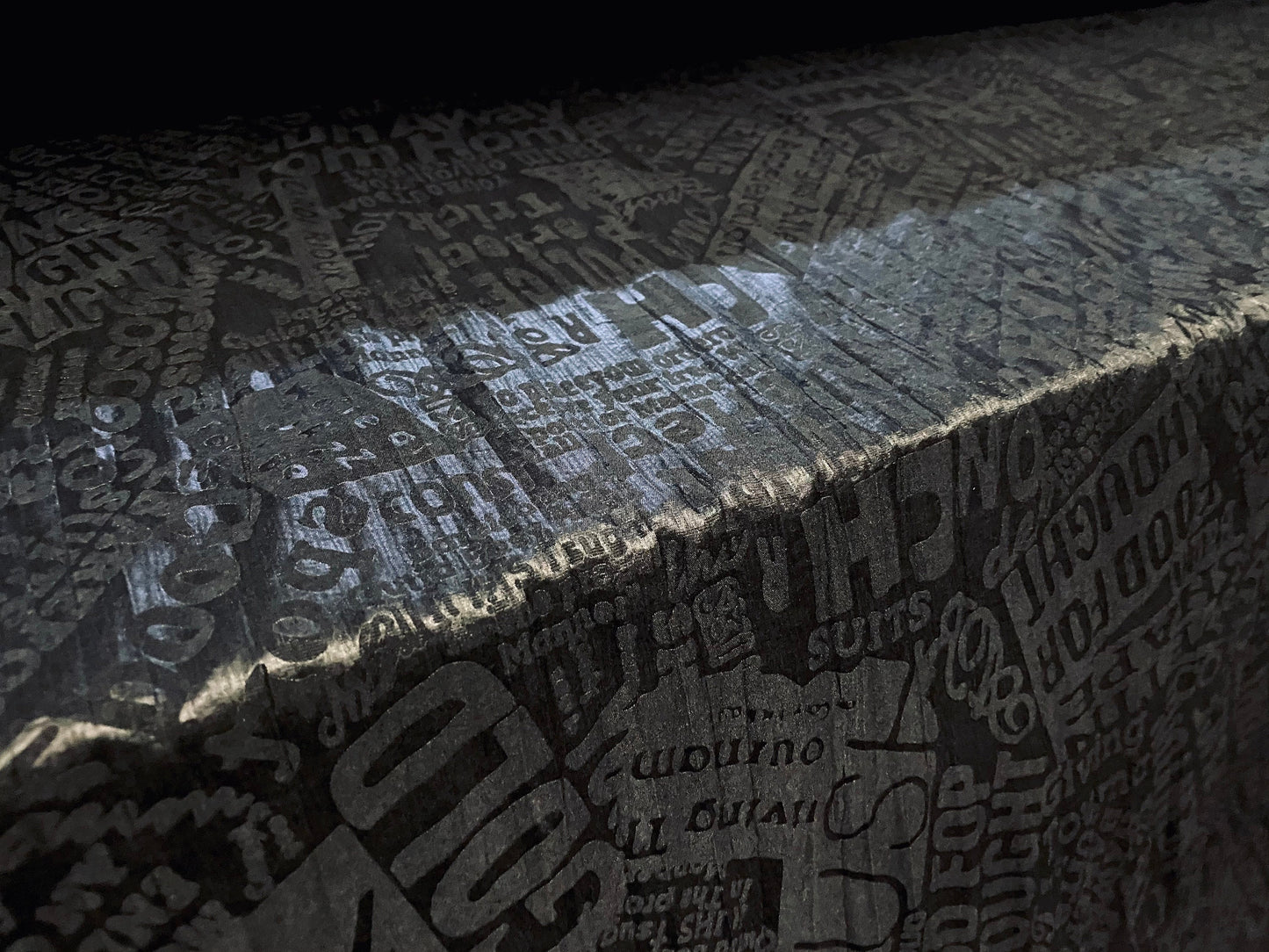 Crinkle woven dress fabric per metre, embossed fashion headlines print - black