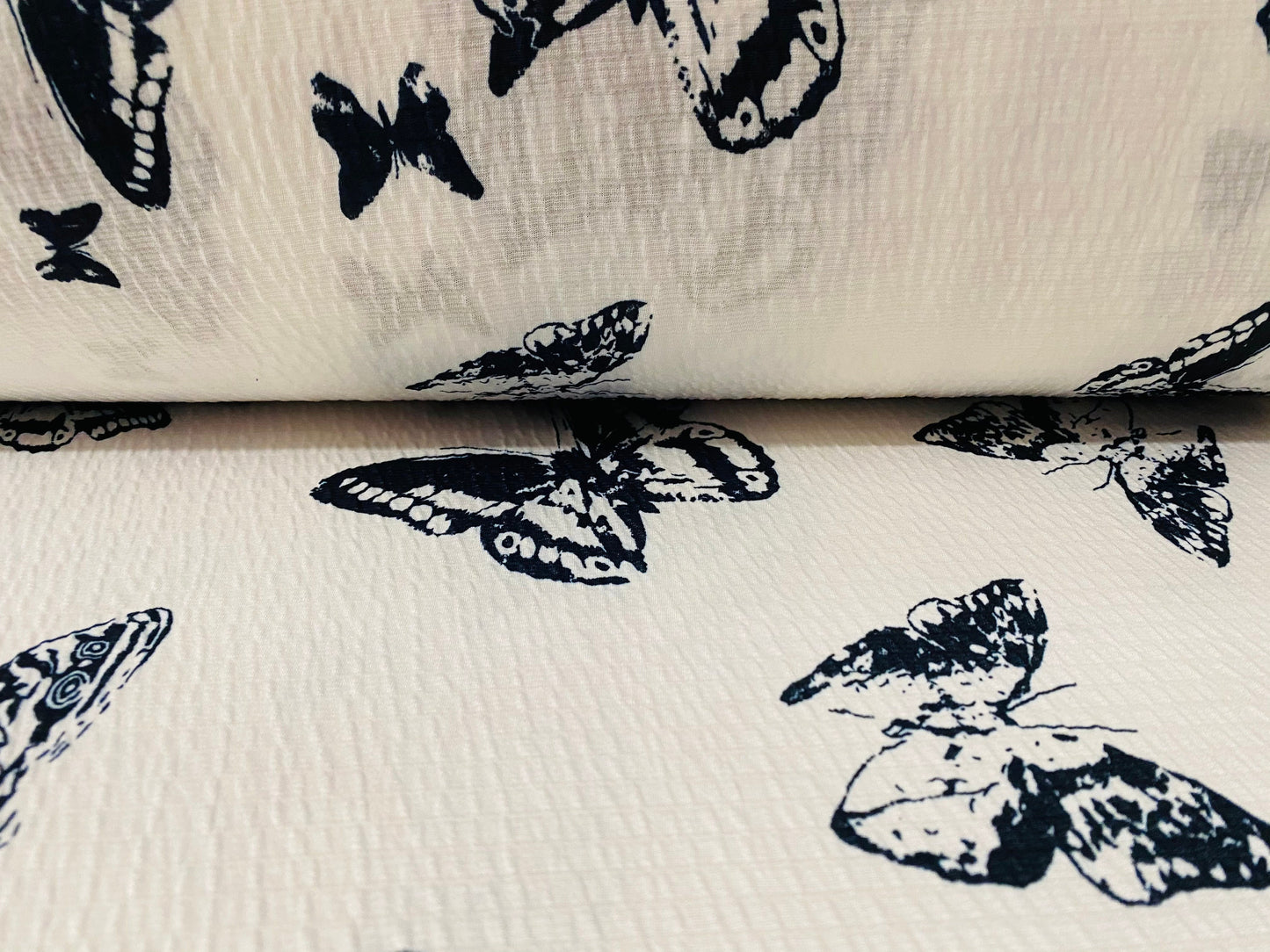 Textured lightweight single jersey dress fabric, per metre - white with black butterfly print - monochrome