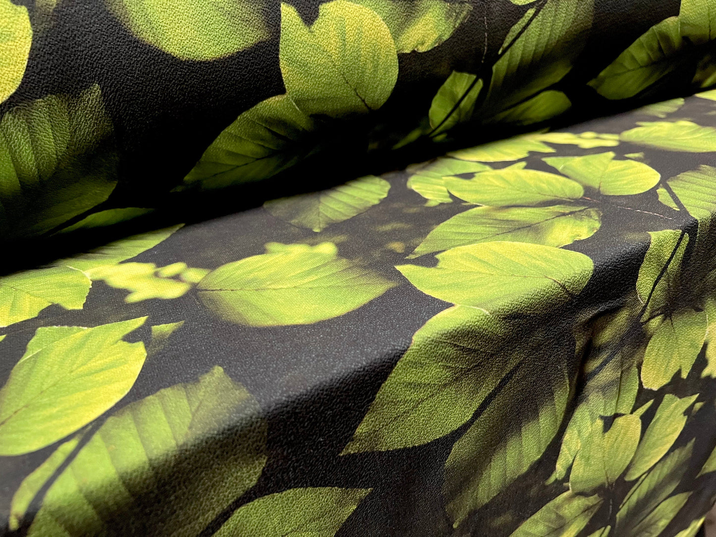 Bubble crepe woven dress fabric with comfort stretch - leaves print - black & green