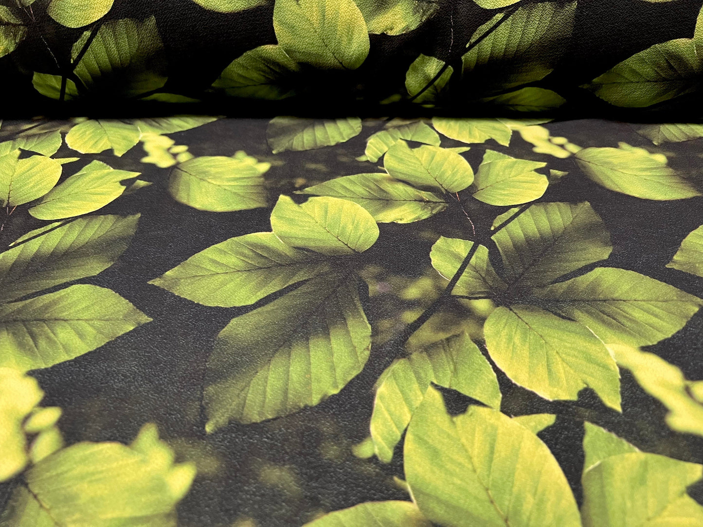 Bubble crepe woven dress fabric with comfort stretch - leaves print - black & green
