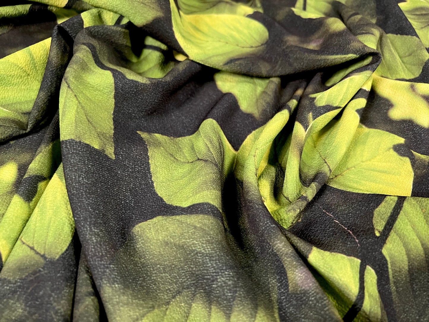 Bubble crepe woven dress fabric with comfort stretch - leaves print - black & green